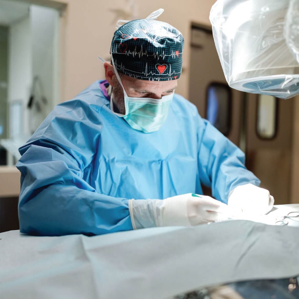 male veterinarian in full scrubs performing surgery